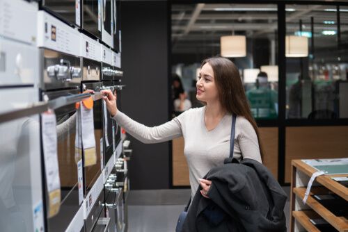 לקוחה מסתובבת בחנות למטרת קניית תנור