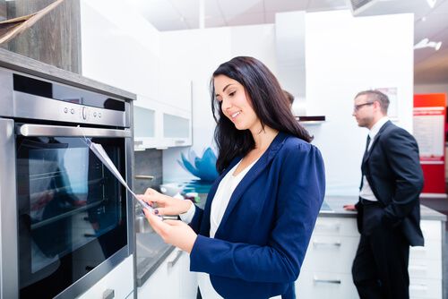 לקוחה נעזרת במדריך איך לקנות תנור בחנות